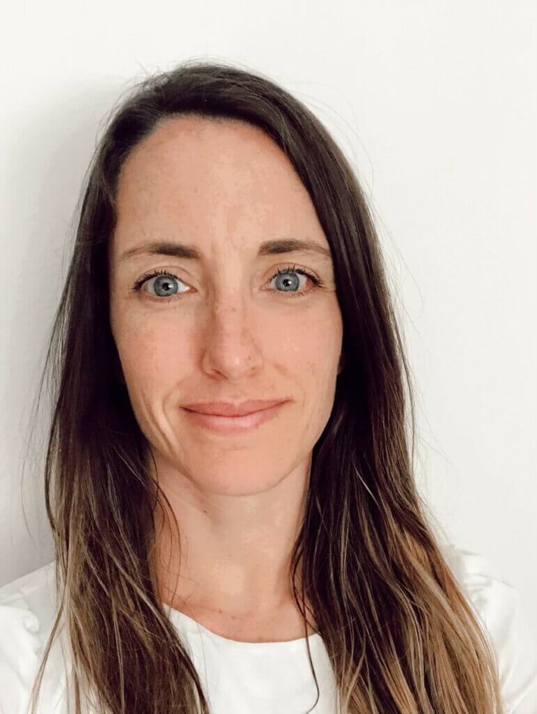 A person standing against a plain white background, looking at the camera.